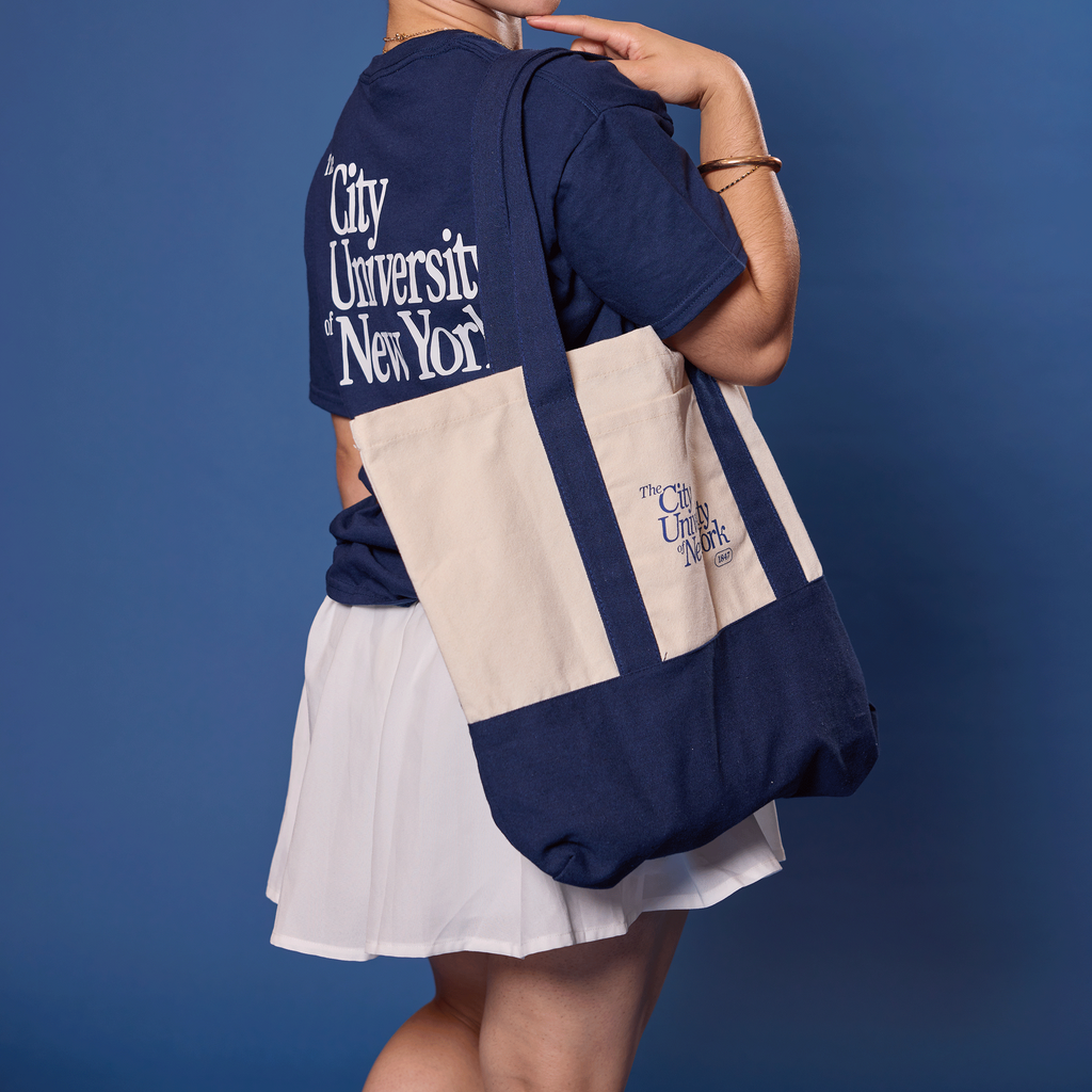 Woman wearing a navy blue shirt with CUNY text, holding a matching tote bag