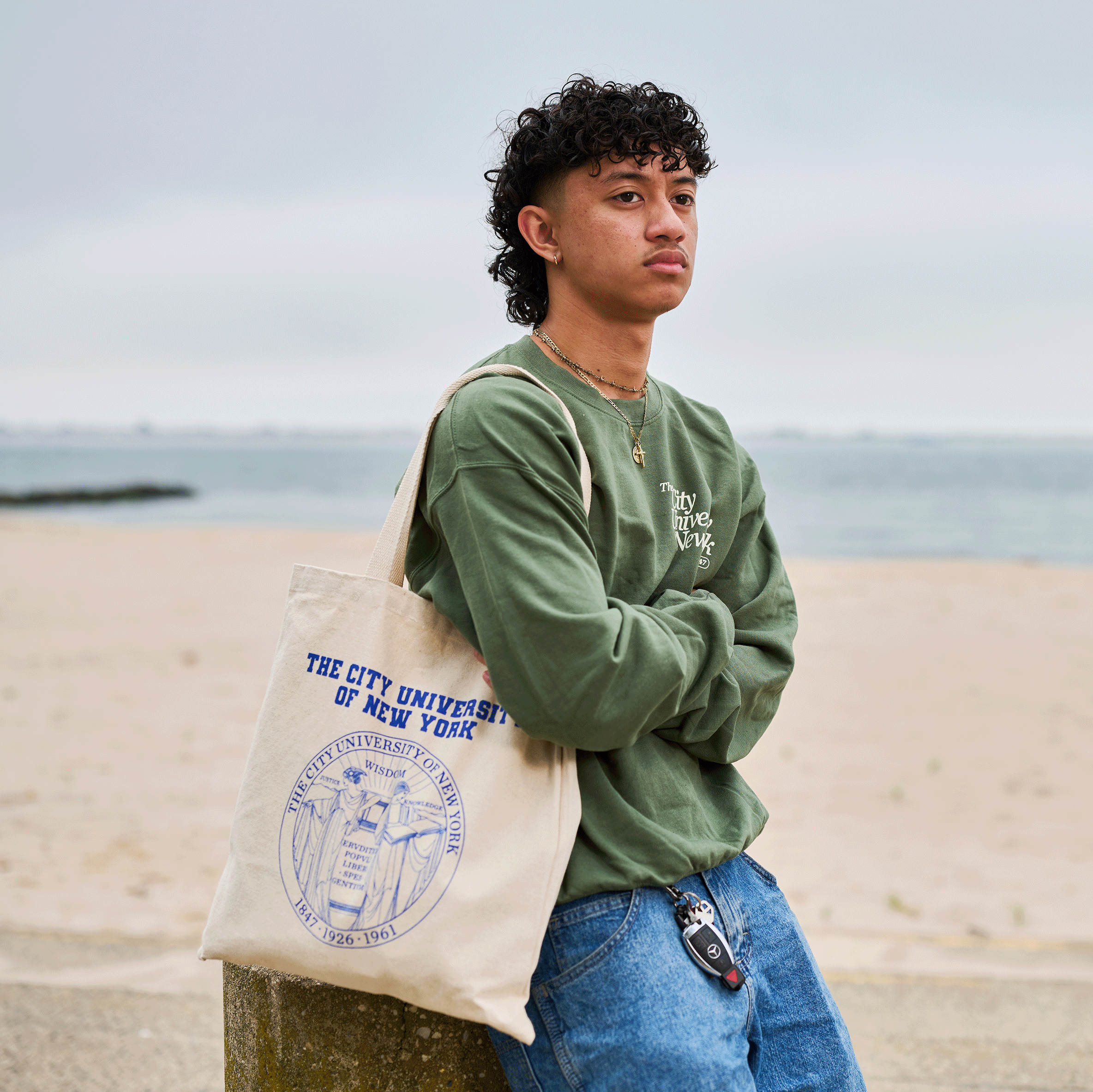 Person holding a tote bag with a visible logo on a beach